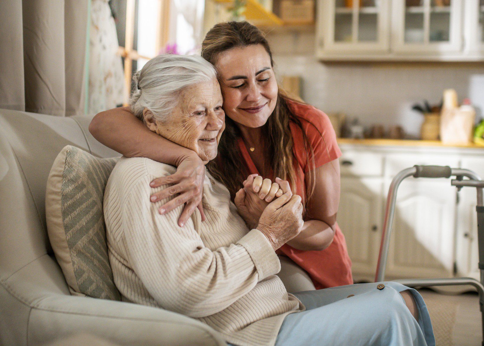Elderly woman and caregiver hugging warmly
