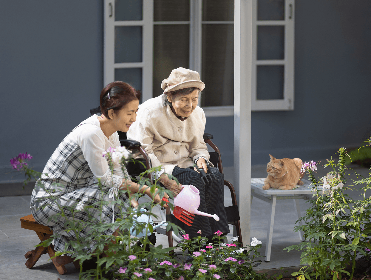 Woman gardening with elderly lady and cat